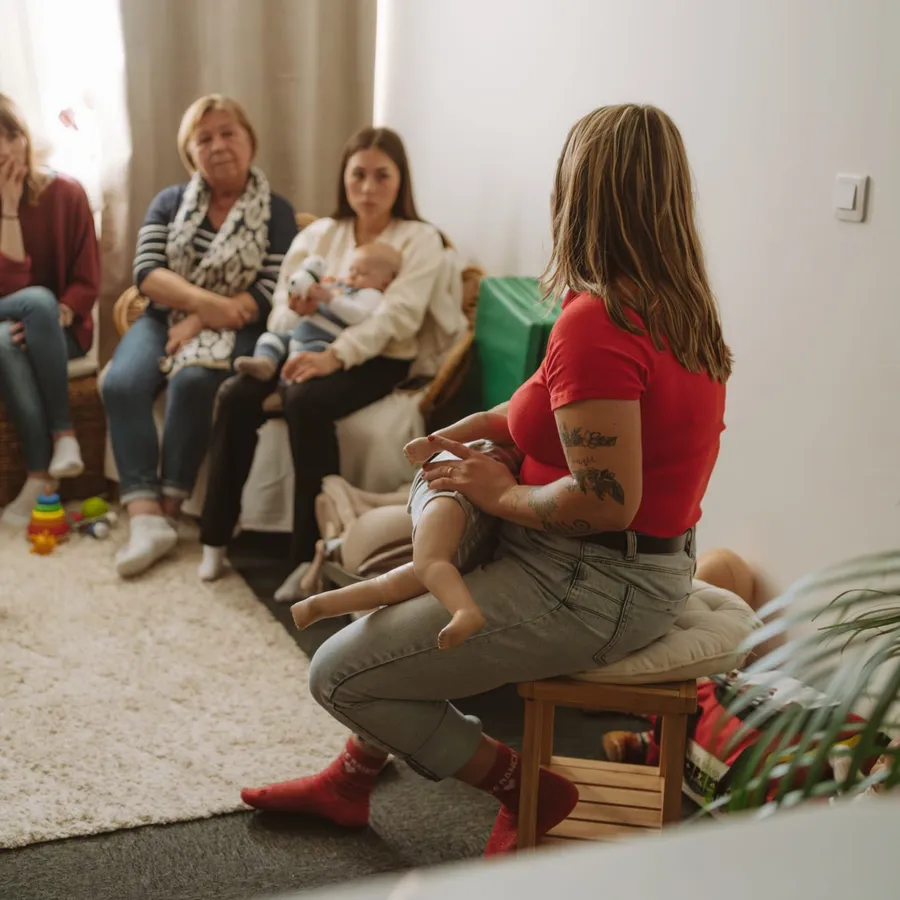 Claire Cohard anime une formation dans un salon, face à trois participantes dont une jeune mère avec son bébé
